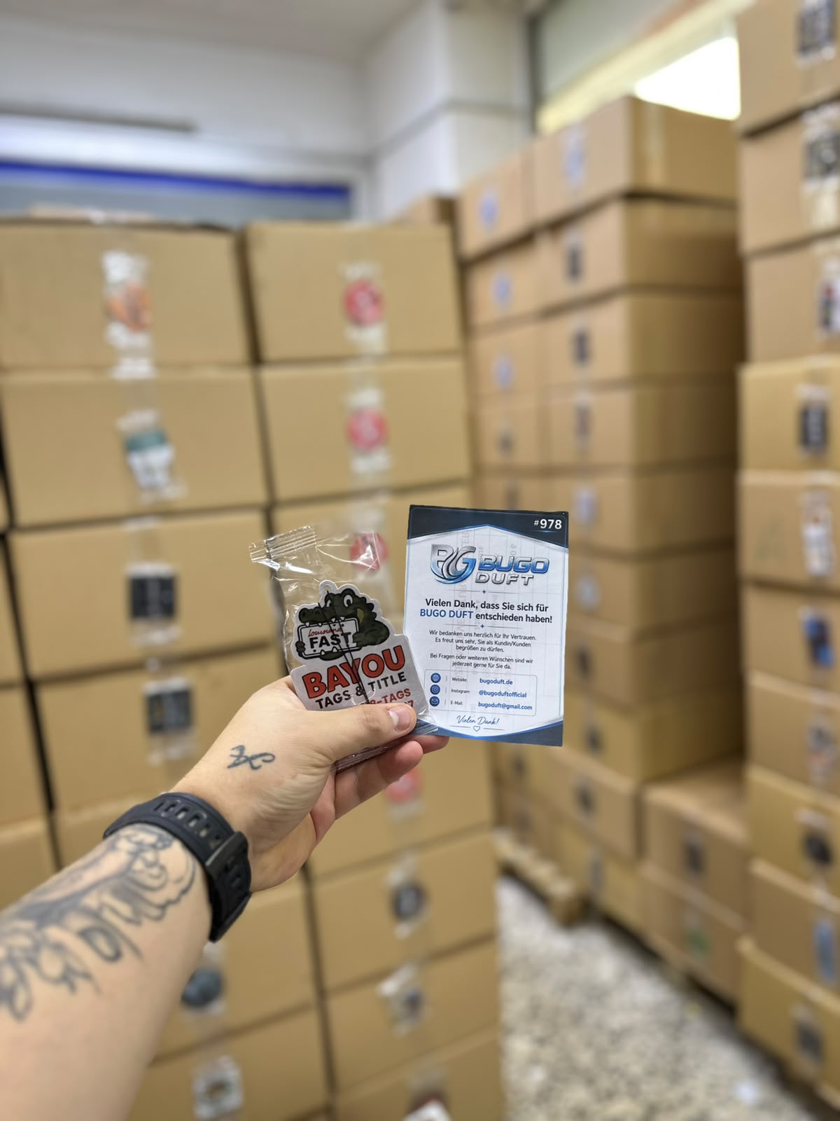Individually packed custom air freshener in front of boxes ready for shipping